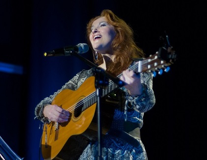 Na zdjęciu kobieta z gitarą.
