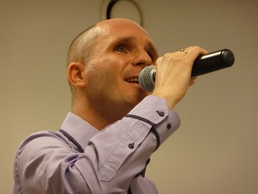 Na zdjęciu młody mężczyzna śpiewa.
