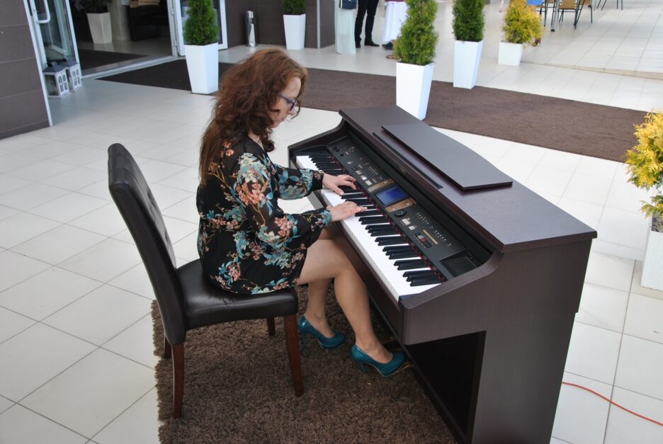 młoda długowłosa kobieta gra na pianinie